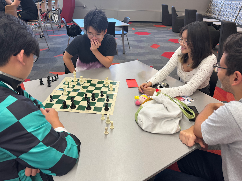 A group of four people playing chess.