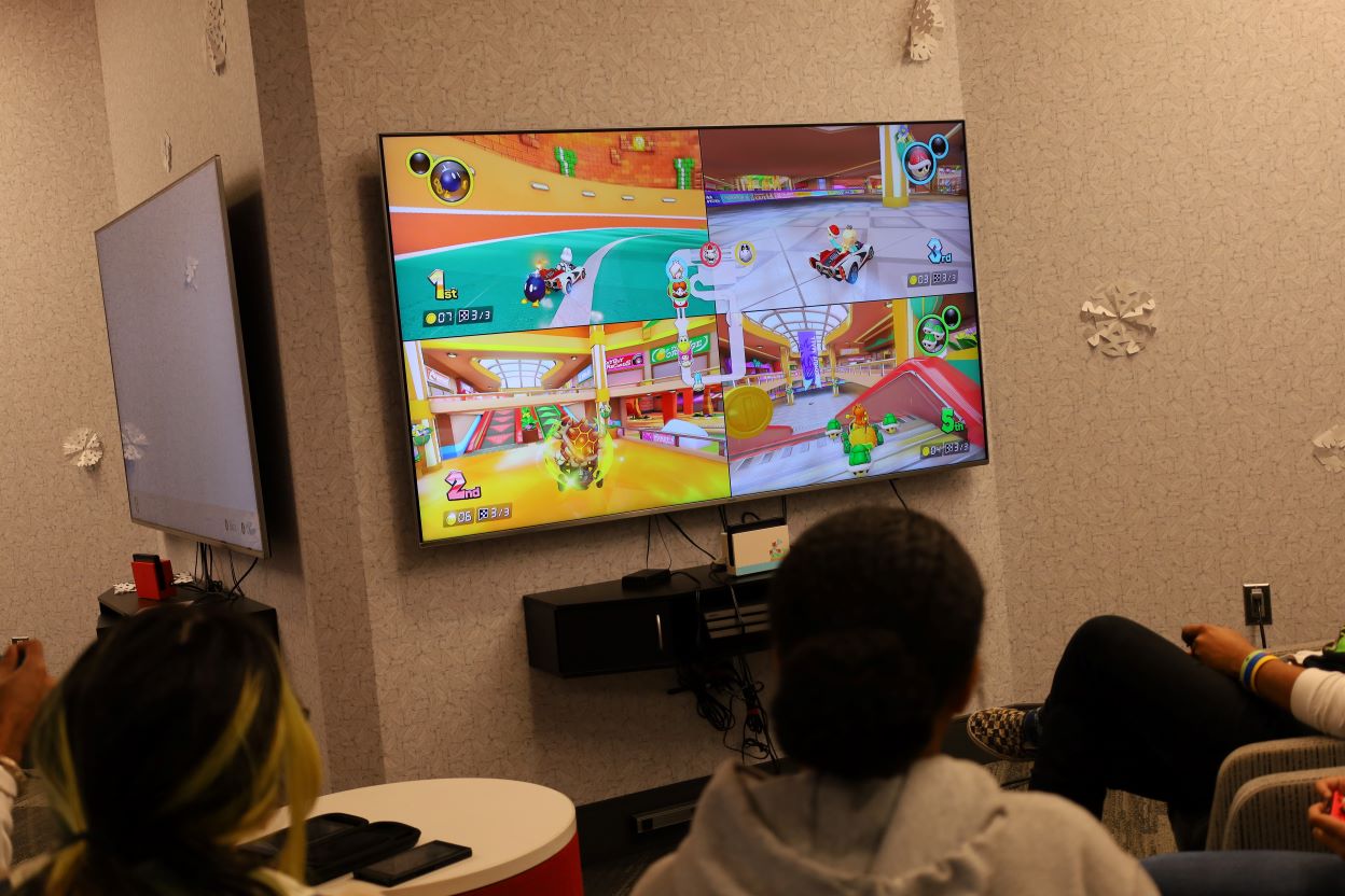 A group of women playing Mario Kart 8 Deluxe.